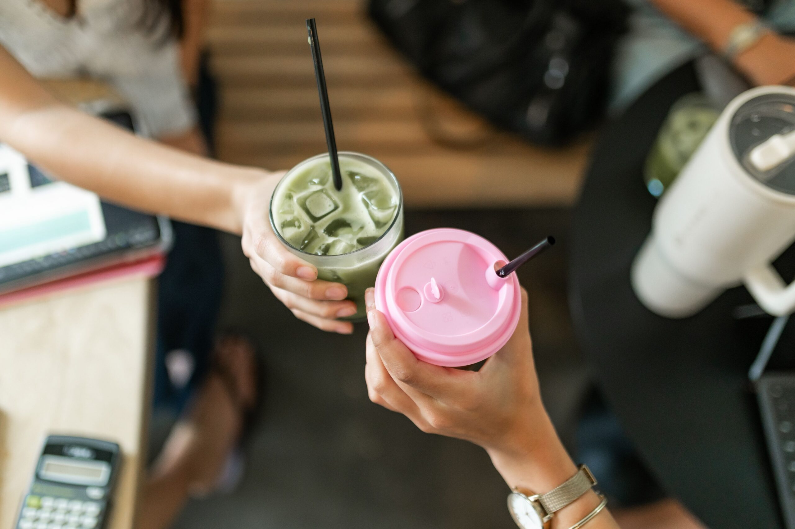 friends clinking iced beverages together scaled