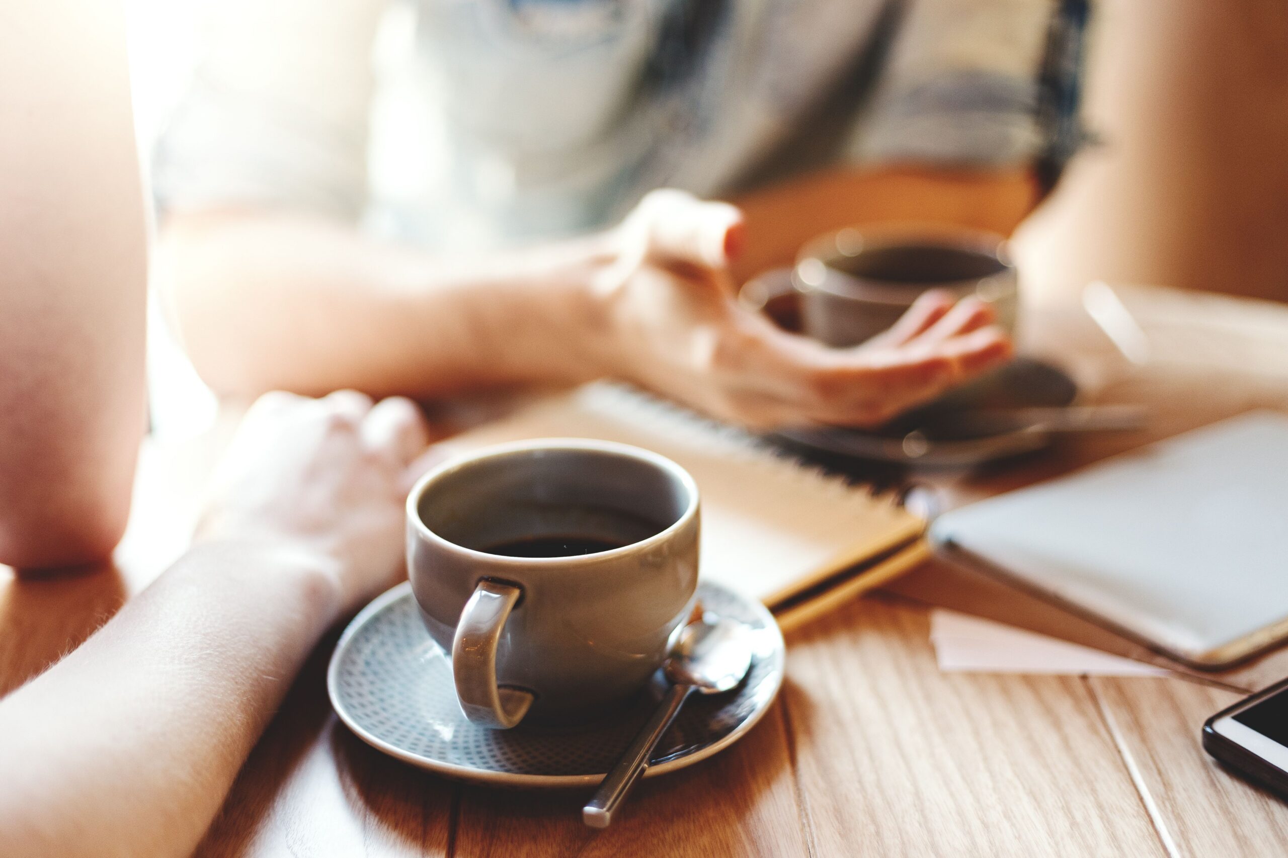 people conversing over cafe coffee scaled
