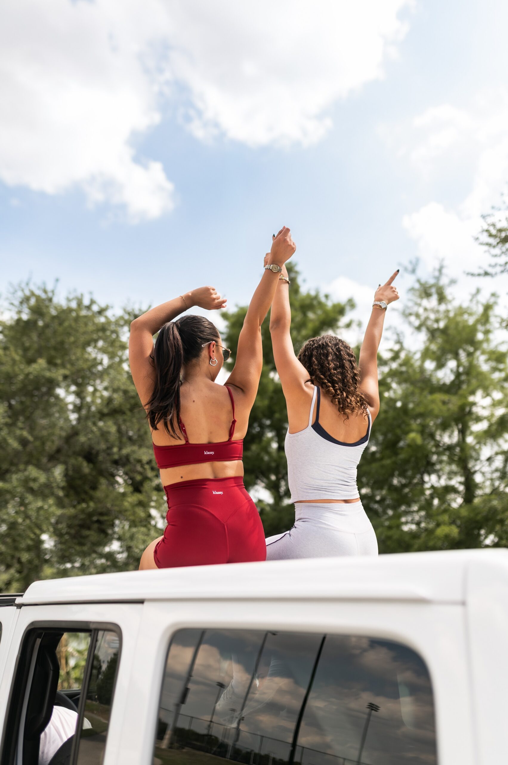 women celebrating on vehicle roof scaled