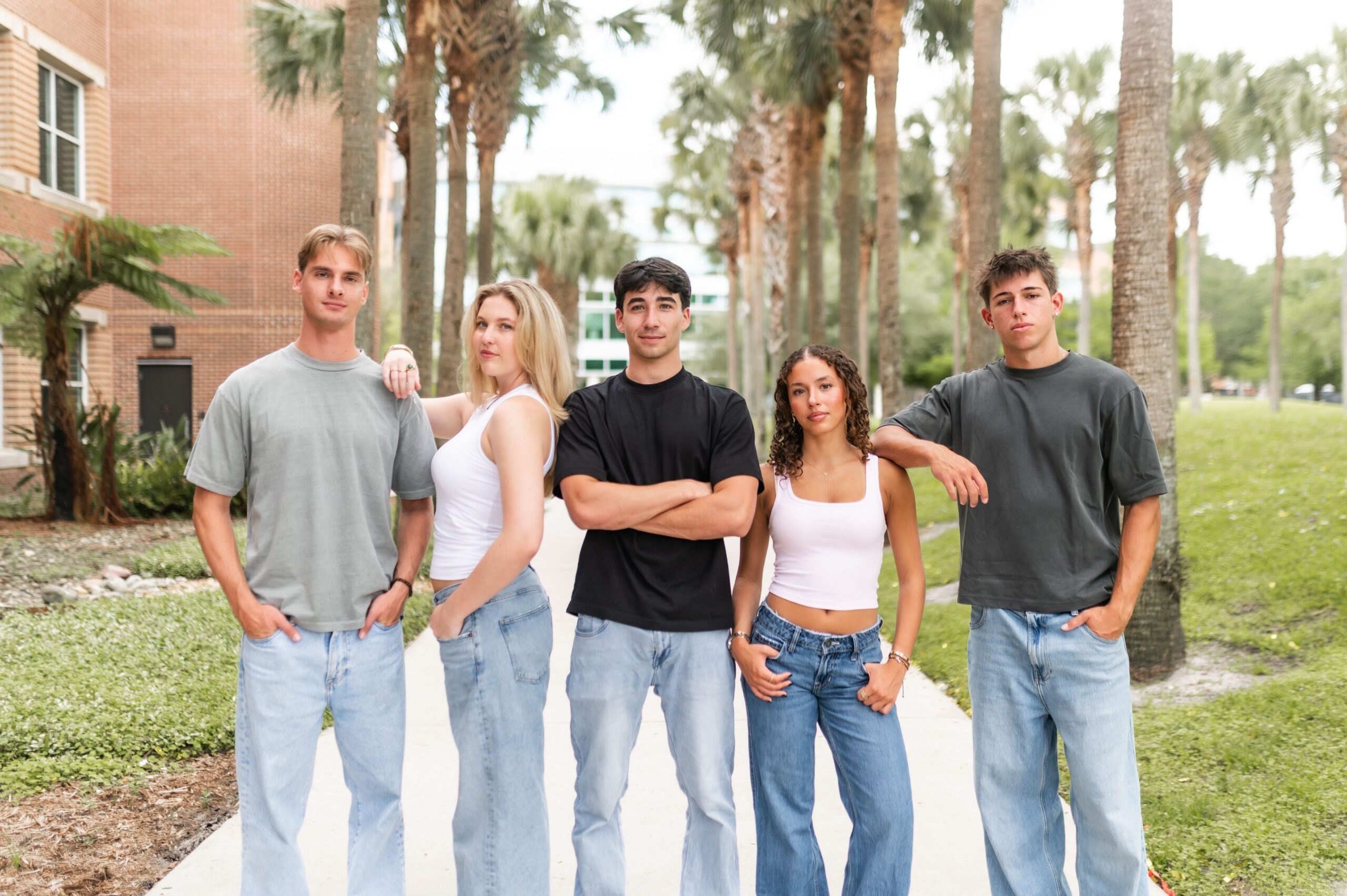 young adults posing on campus walkway scaled