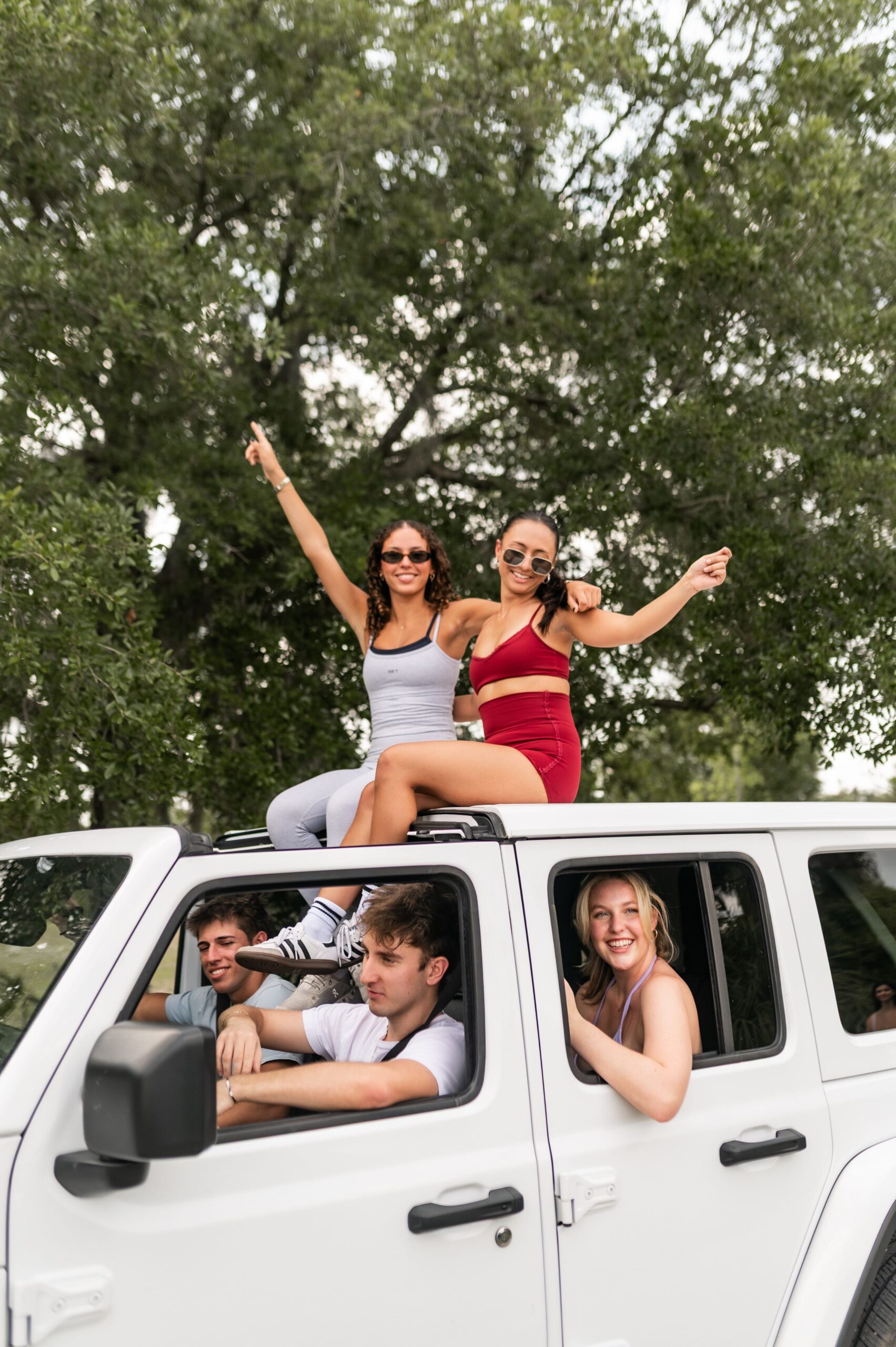 young friends posing on white suv scaled