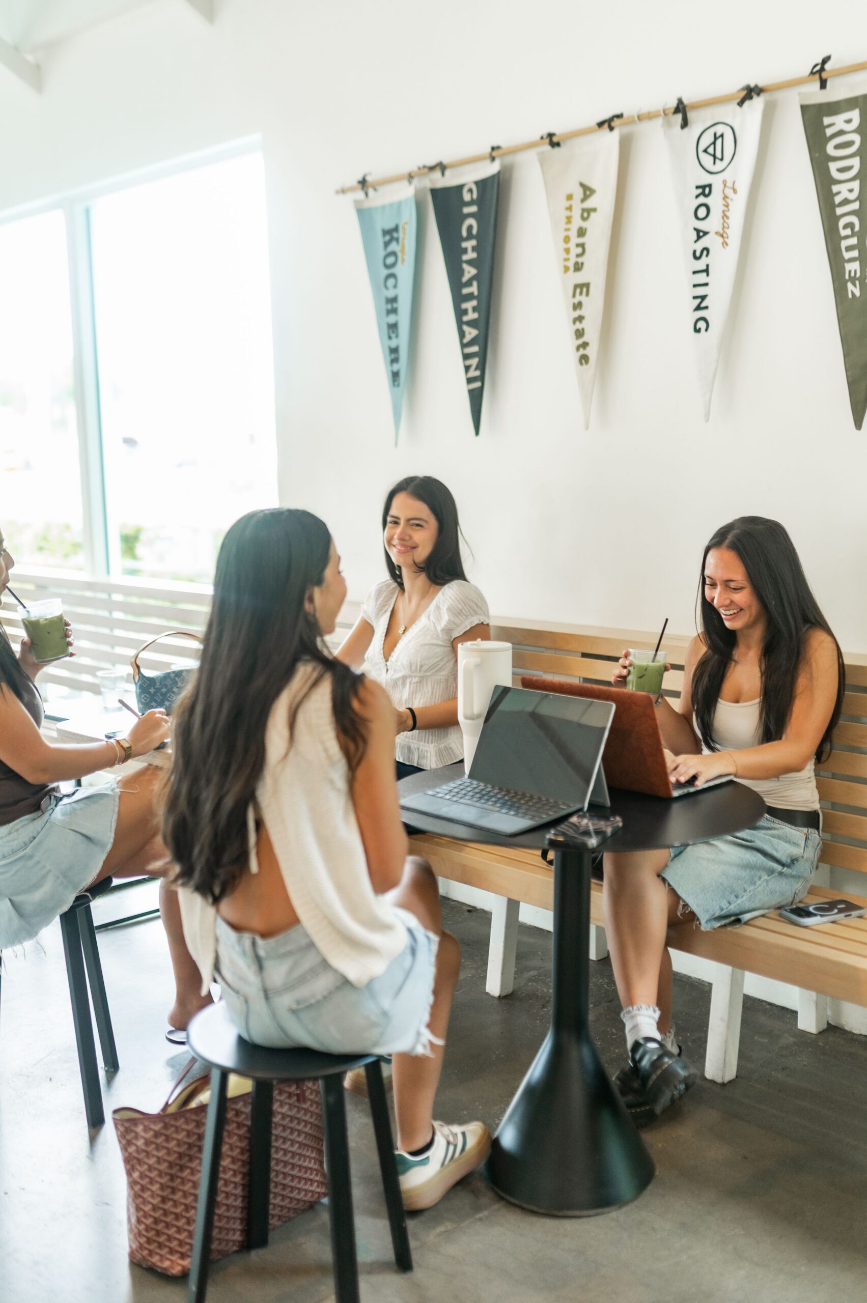 young women socializing at cafe table scaled
