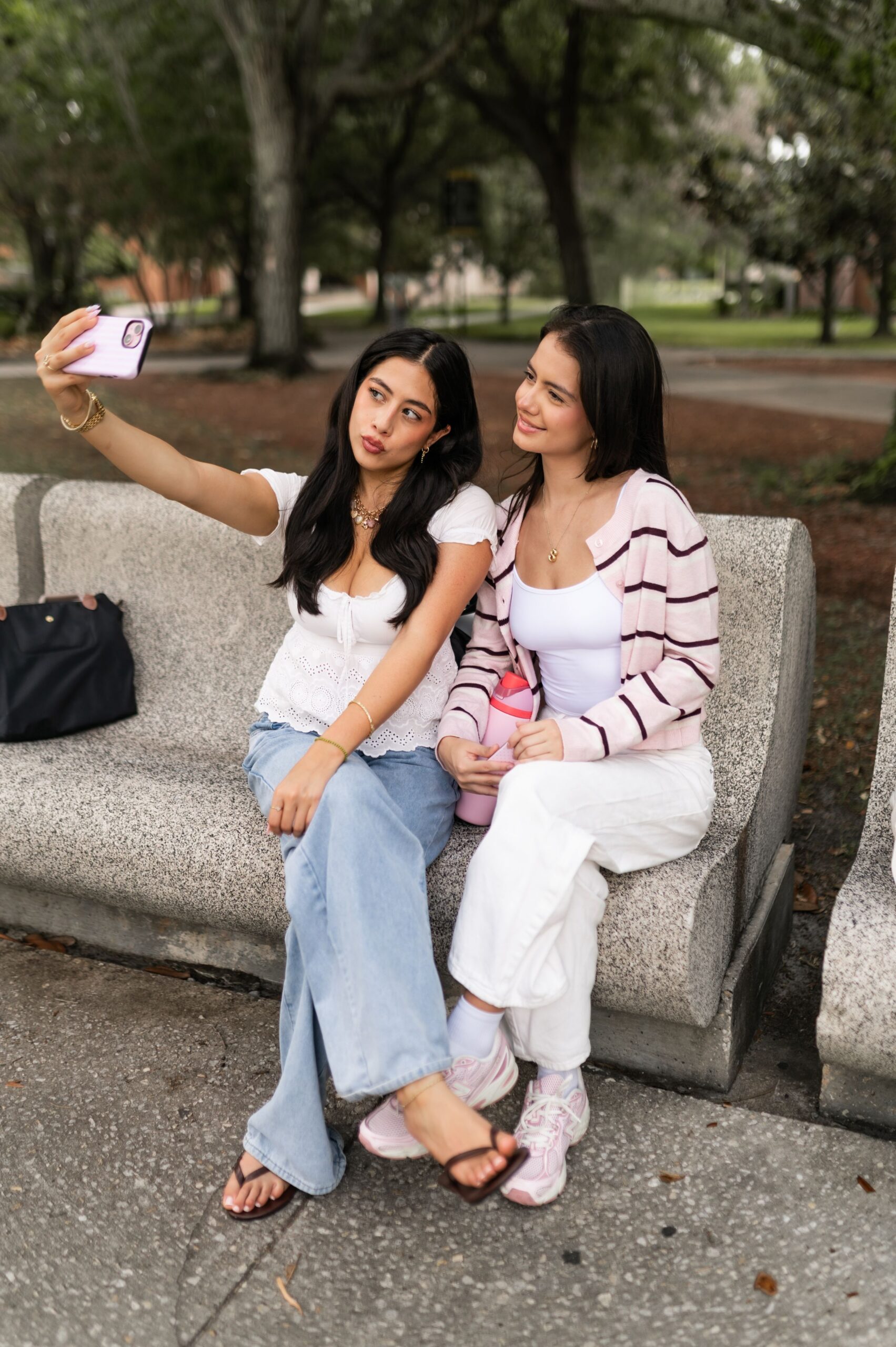 young women taking selfie on bench scaled
