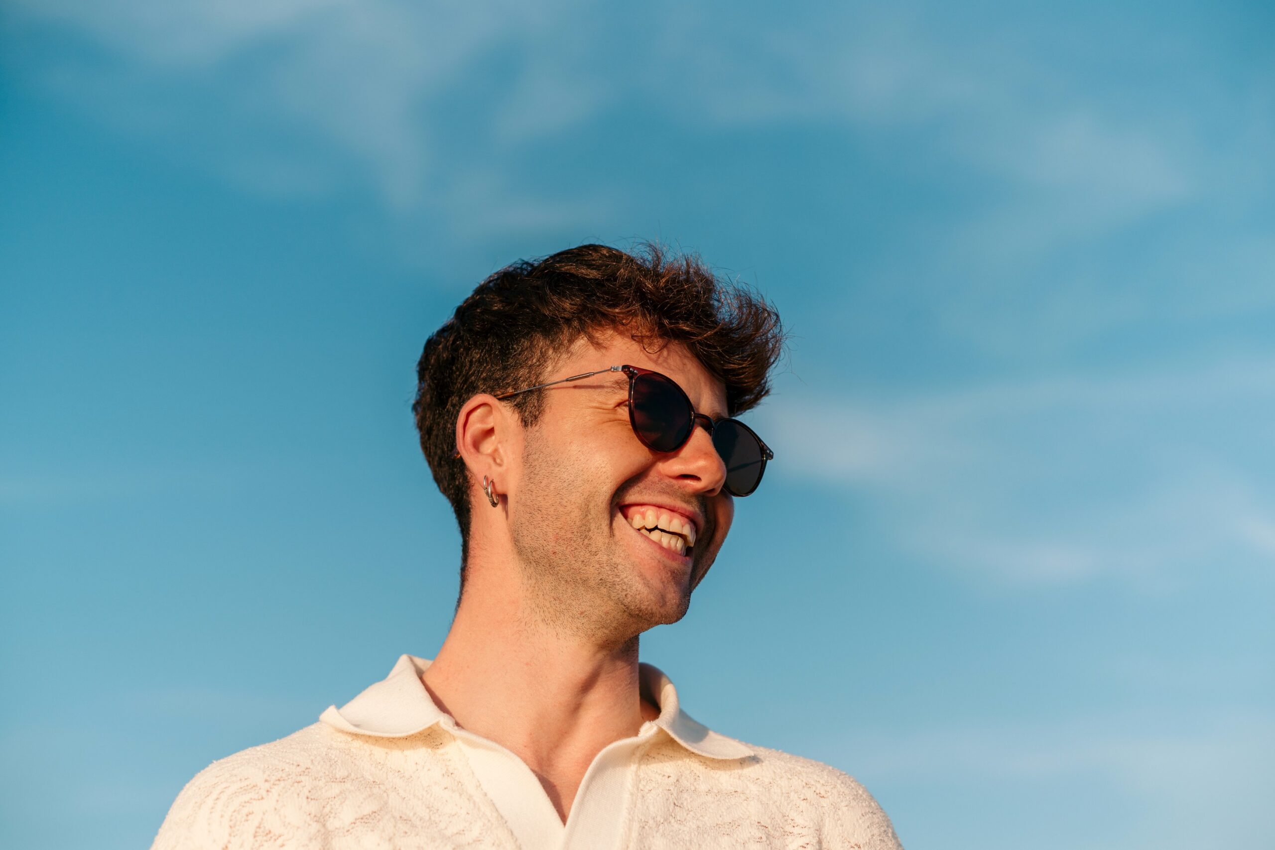 Young man in sunglasses smiling scaled